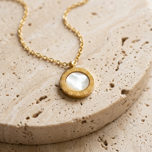 Cove Reversible Pendant Necklace showing the mother-of-pearl side on pale travertine