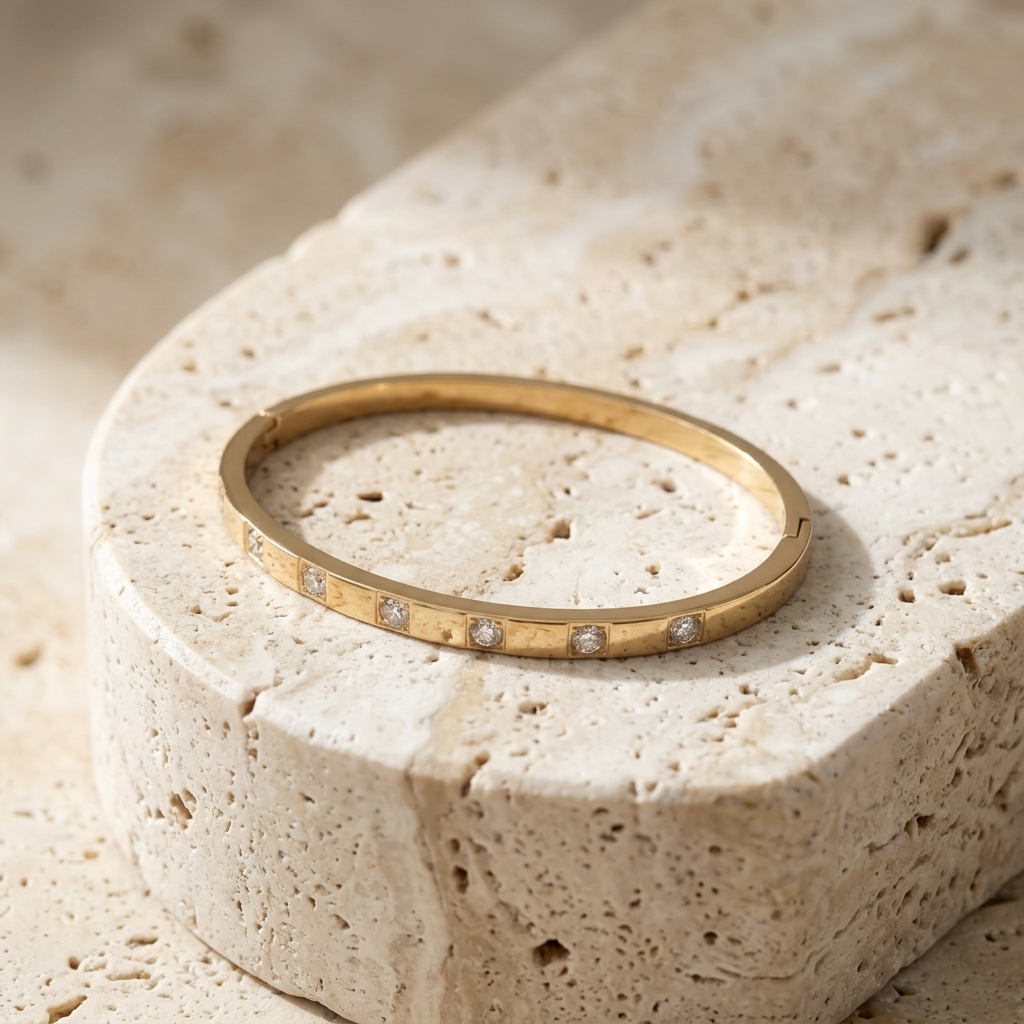 Whitecliff Crystal Bangle resting on pale travertine with its crystals facing forward