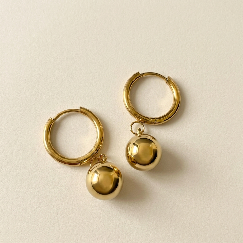 Pair of Luna Drop Earrings with polished gold hoops and rounded ball drops