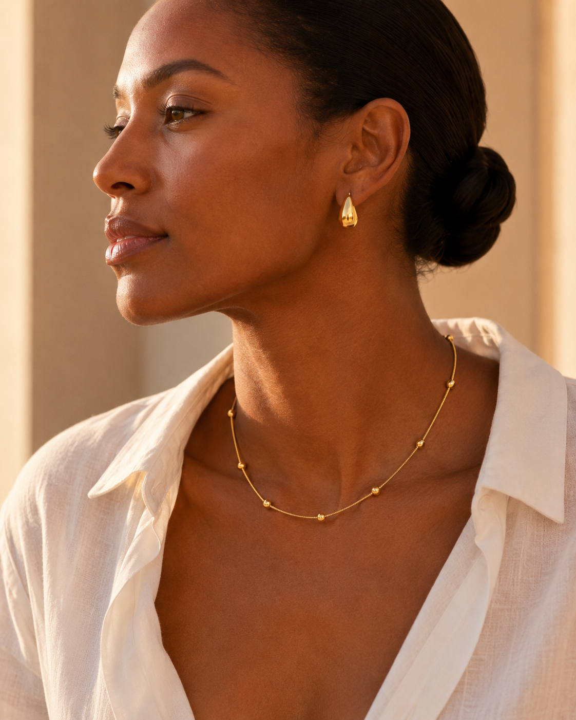 Model wearing the delicate Celestial Bead Necklace with an open white shirt