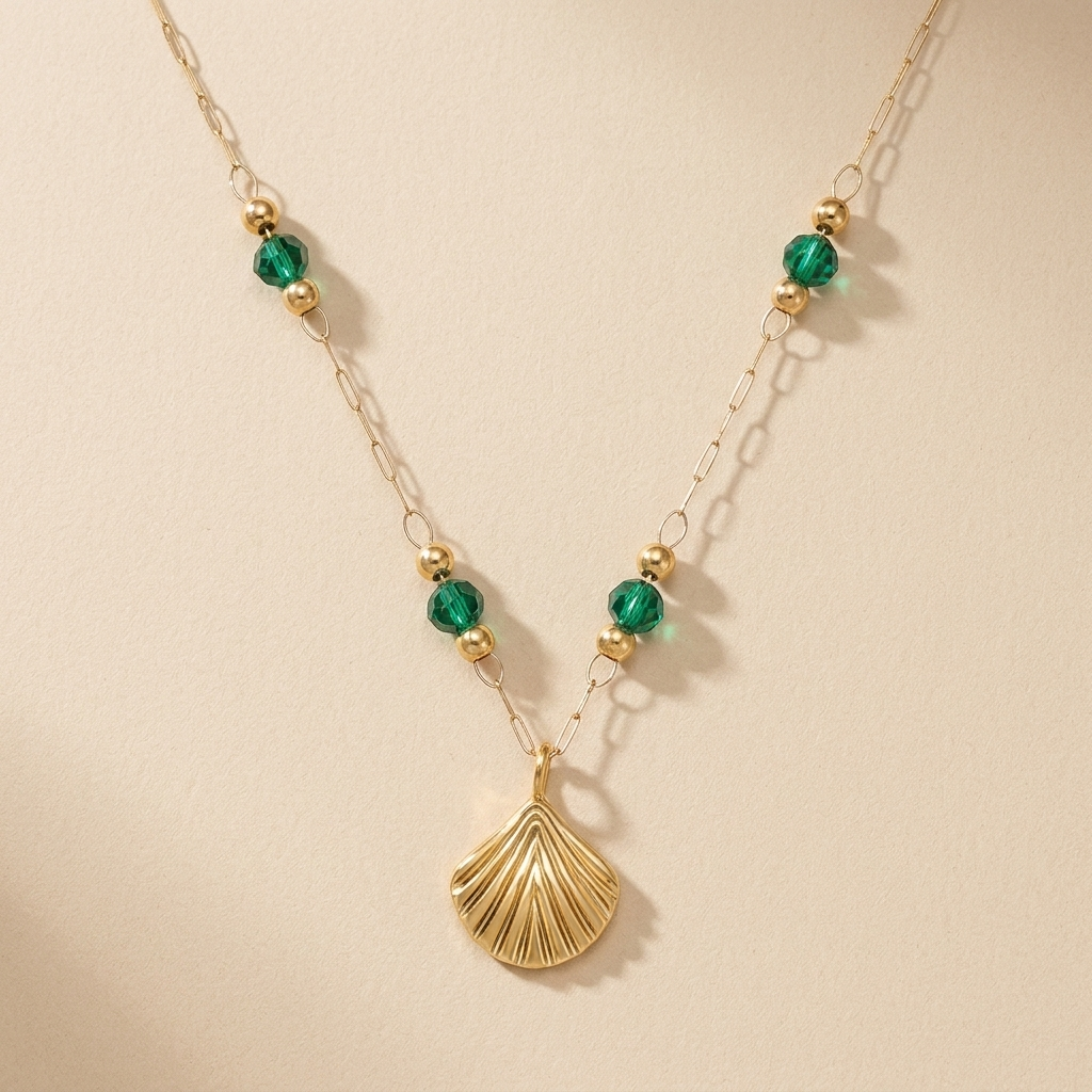 Seabright Shell Pendant Necklace laid flat with green beads and a gold shell charm