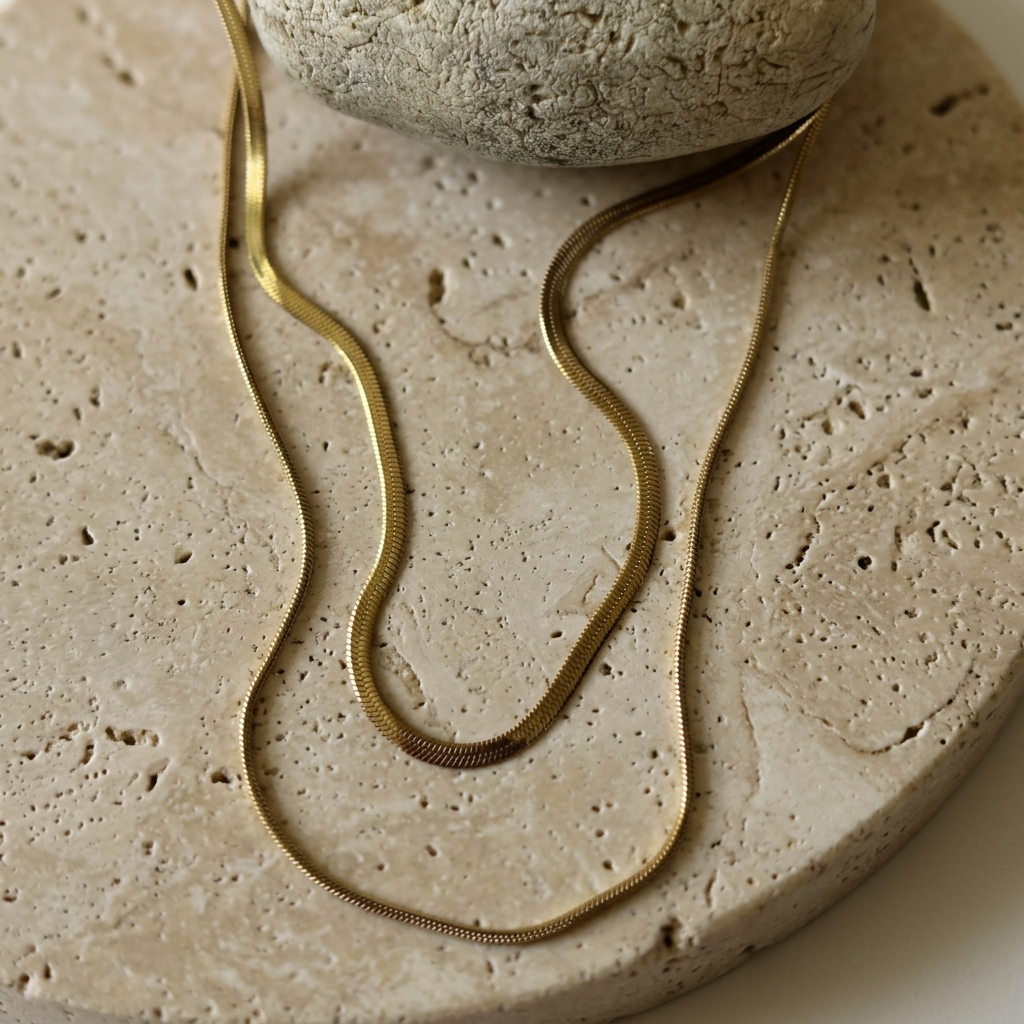 Shoreline Layered Necklace arranged on pale travertine to show both gold chains